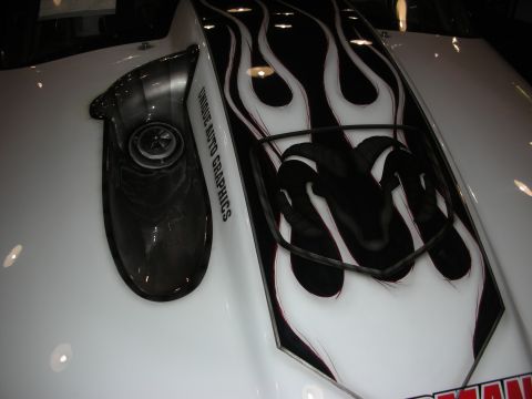 1998 Ford Crown Victoria - white car hood with a black scoop and black-and-pink flame graphics surrounding a stylized Ram's-head logo.