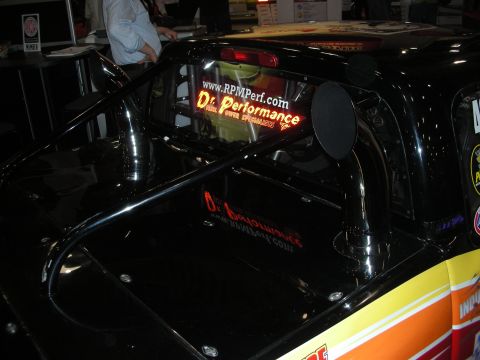 1998 Ford Crown Victoria - black race car's side window and roll bar marked with 'www.RPMPerf.com' and 'Dr. Performance' lettering.