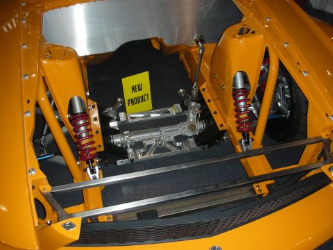 1998 Ford Crown Victoria - orange race car's exposed front end showing red coilover shocks, tubular control arms, and a 'New Product' display card.