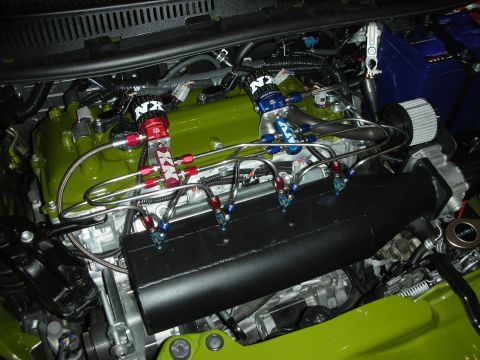 1998 Ford Crown Victoria - lime-green painted engine fitted with twin NX nitrous solenoids feeding a web of braided distribution lines over a black cover.