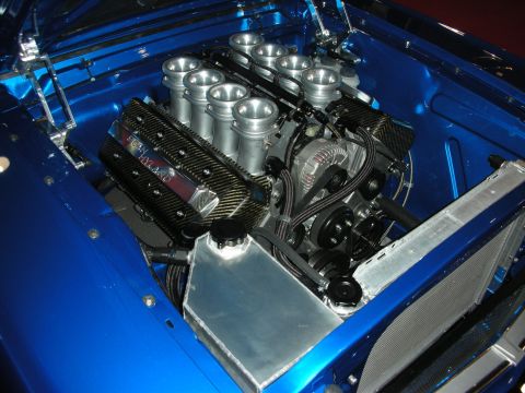 1998 Ford Crown Victoria - V8 with carbon valve covers, individual throttle-body stacks and a polished aluminum tank installed in a bright blue engine bay.