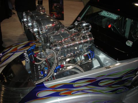 1998 Ford Crown Victoria - Highly polished supercharged V8 engine mounted in a custom car body painted with blue and orange flames.