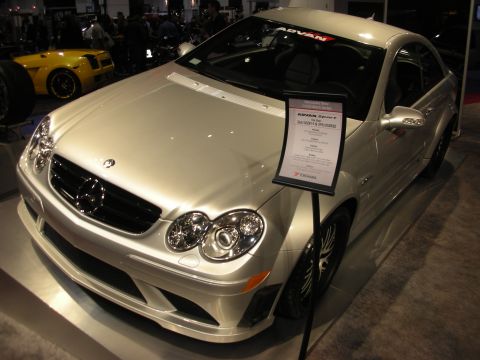 1998 Ford Crown Victoria - Silver Mercedes-Benz CLK coupe displayed on a stand with an Advan tire placard, a yellow car behind it.