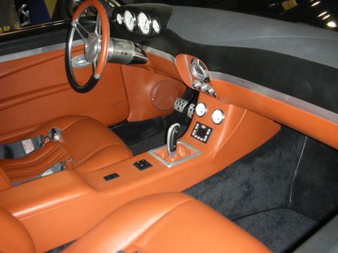 1998 Ford Crown Victoria - Custom tan leather interior featuring a billet steering wheel, round gauges, a console-mounted chrome shifter and black carpet.