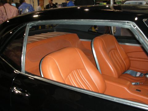 1998 Ford Crown Victoria - View through the side window of a black coupe showing custom tan leather bucket seats and chrome trim.