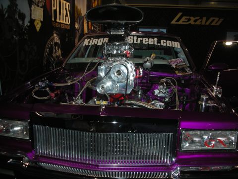 1998 Ford Crown Victoria - Front view of a purple custom car with an exposed chrome supercharged engine and KingoftheStreet.com text on the windshield.