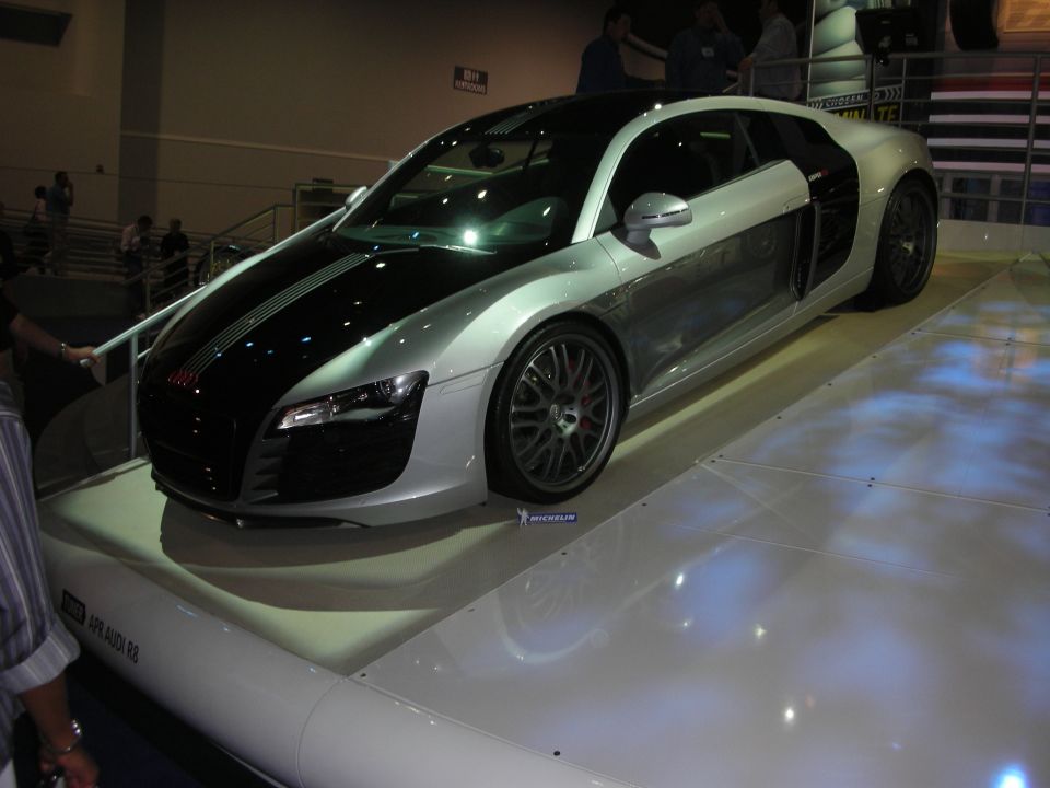 Silver and black Audi R8 sports coupe on a lit show platform