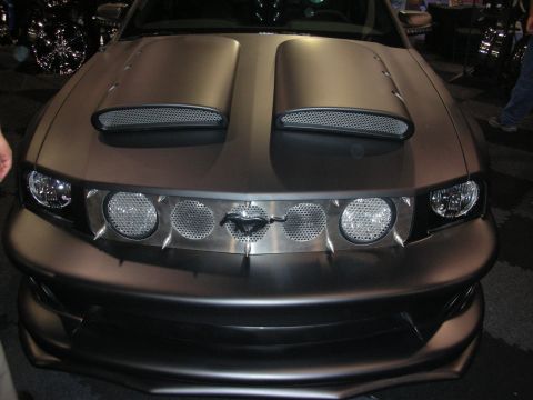 1998 Ford Crown Victoria - matte-brown custom Ford Mustang shows twin hood scoops, a pony grille emblem, and round auxiliary lights across the front.