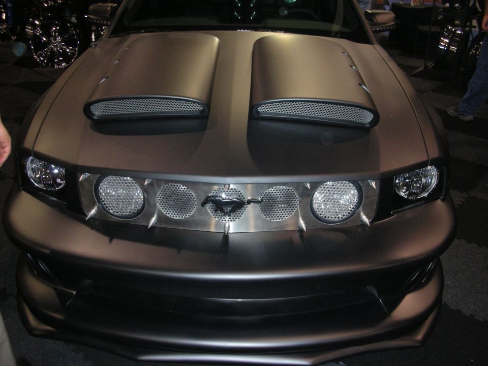 Front view of a matte-brown Ford Mustang with twin hood scoops and round lights