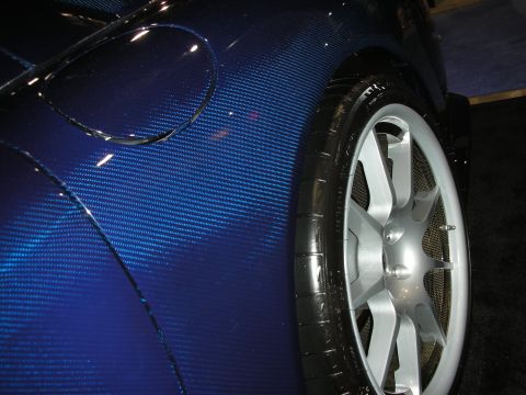 1998 Ford Crown Victoria - close-up shows the blue carbon-fiber bodywork and silver multi-spoke wheel of a low-slung show car.