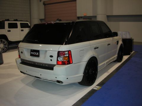 1998 Ford Crown Victoria - white Range Rover Sport with black wheels sits on a carpeted show stand, an MDZ badge on the rear hatch.