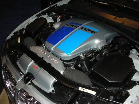 1998 Ford Crown Victoria - engine bay shows a silver Hartge-branded V10 intake cover with a blue stripe, a Castrol cap, and braided lines under an open hood.