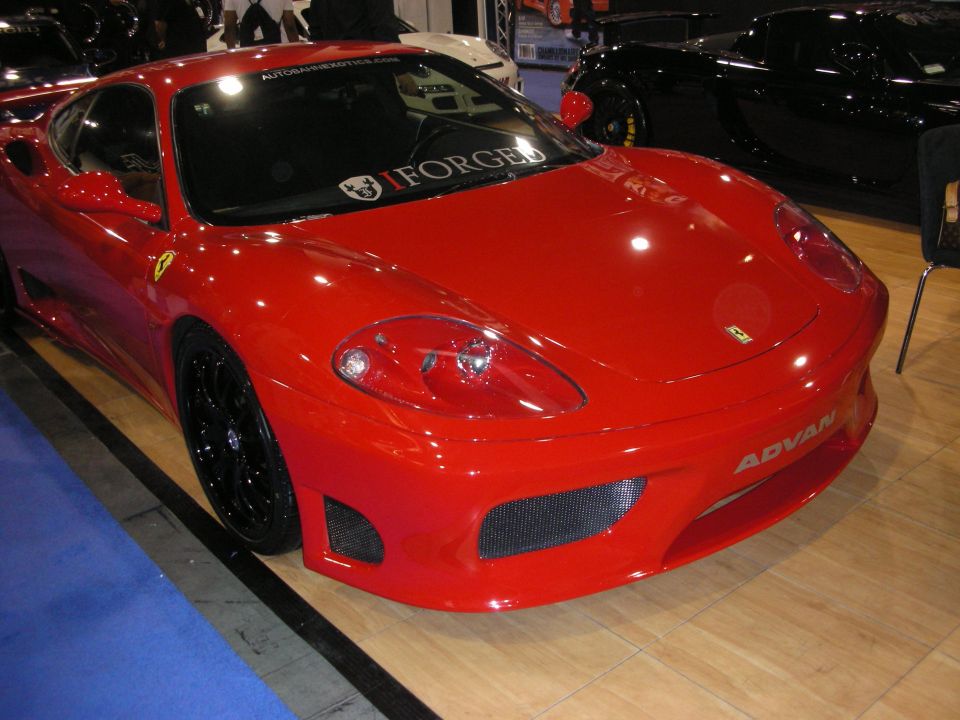 Red Ferrari 360 Modena coupe with black wheels and Advan decals on show carpet