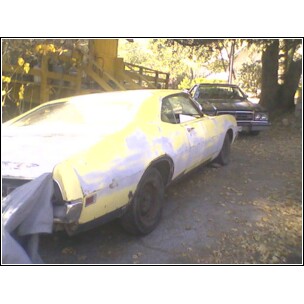 1971 Mercury Cyclone - A yellow car, partially covered in primer, is parked outdoors with another vehicle in the background.