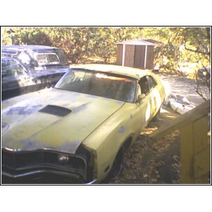 1971 Mercury Cyclone - A weathered 1971 Mercury Cyclone GT sits in a yard with other vehicles and structures visible.