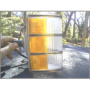1973 Ford Ranchero - Car turn signal assembly with amber and clear lenses, held by a hand.