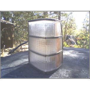 1973 Ford Ranchero - A clear plastic tail light assembly with three stacked sections is shown resting on a dark surface outdoors.