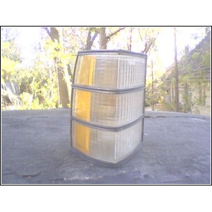 1973 Ford Ranchero - A car tail light assembly with amber and clear sections sits on a dark surface outdoors.