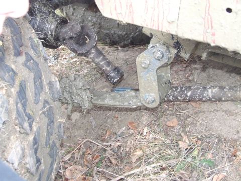 1990 Ford Bronco - Close-up view of heavily soiled drivetrain and suspension parts of an off-road vehicle.