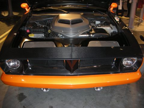 1998 Ford Crown Victoria - Open front of an orange coupe showing a carbon-fiber front panel and a chrome air-box shroud over the engine.