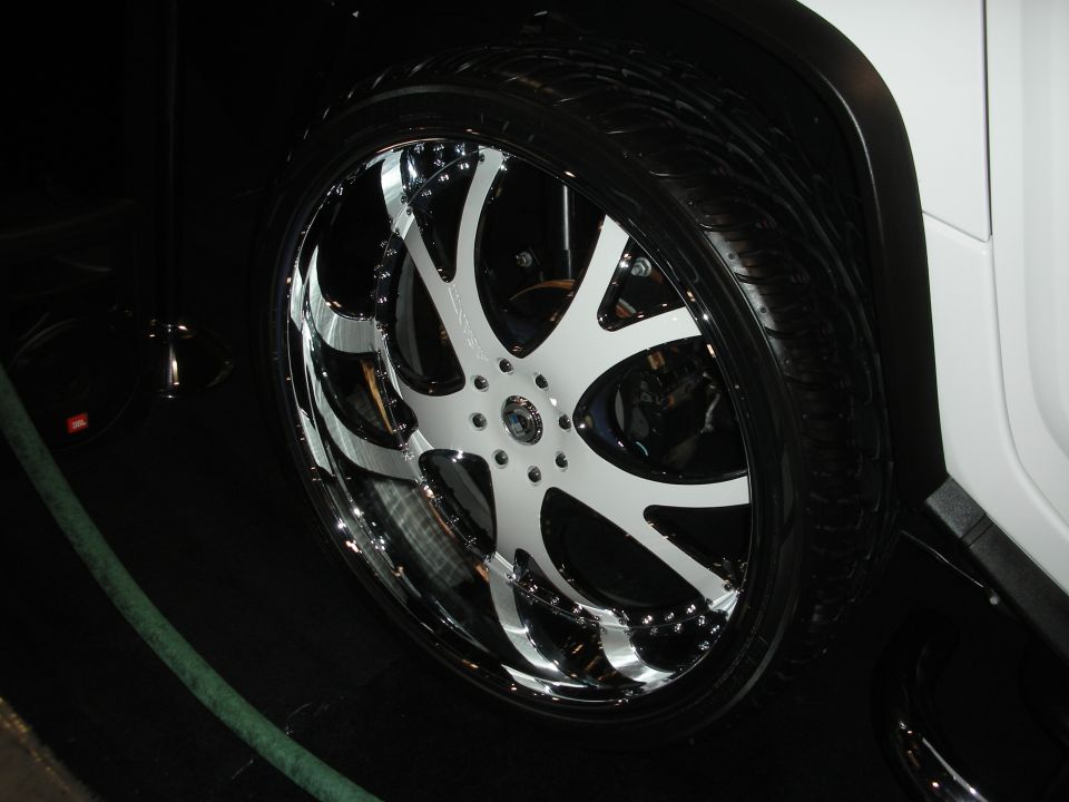 Large chrome and white seven-spoke wheel on a white SUV