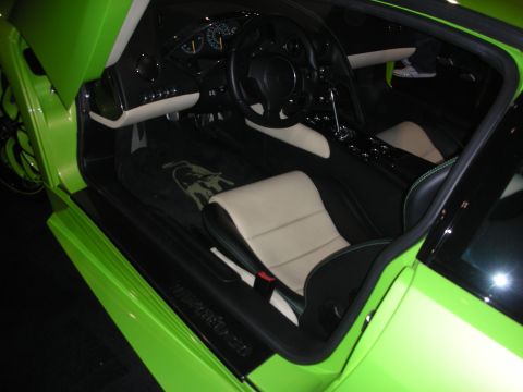 1998 Ford Crown Victoria - Interior of a bright green sports car showing two-tone black and cream leather seats and a wheel-mounted dashboard.