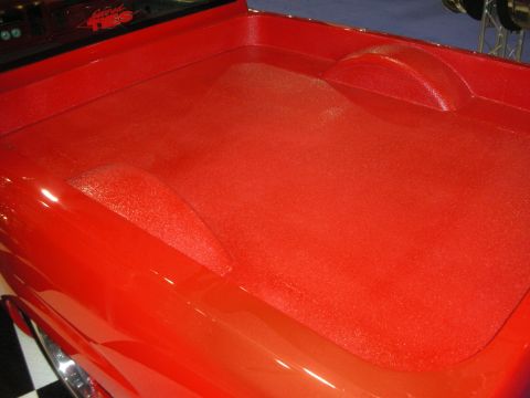 1998 Ford Crown Victoria - Close-up of a glossy candy-red metalflake painted truck bed with smoothed wheel humps.