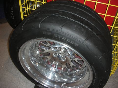 1998 Ford Crown Victoria - wide Mickey Thompson ET Street drag radial tire mounted on a polished multi-piece wheel on display.