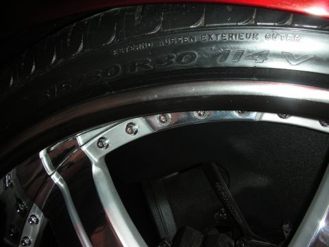 1998 Ford Crown Victoria - Macro shot of a polished wheel barrel with riveted lip and a 315/30R30 114V tire sidewall marking.