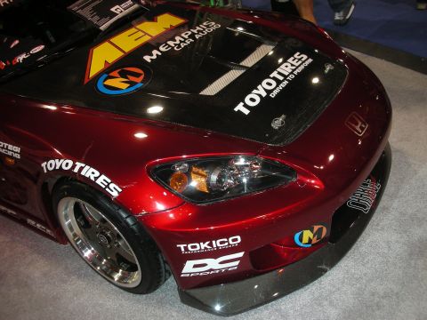 1998 Ford Crown Victoria - Front quarter of a deep-red Honda convertible race car with carbon hood and Toyo Tires, AEM and Tokico sponsor decals.