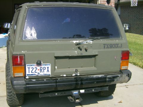 1993 Jeep Cherokee - The rear of a Jeep Cherokee shows a license plate and custom markings on the tailgate.