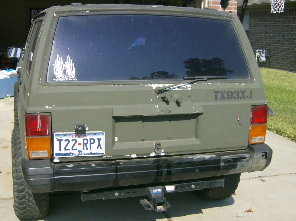 Rear view of a 1993 Jeep Cherokee with a license plate that reads T22-RPX and 'TX93XJ' on the tailgate