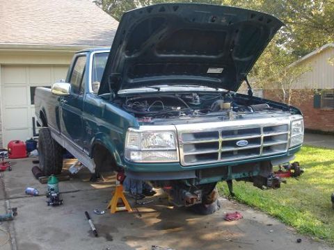 1996 Ford F-150 - Front view of a green 1996 Ford F-150 pickup truck undergoing repairs with its hood open.