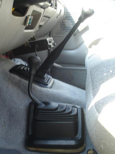1996 Ford F-150 - The interior of a vehicle shows a center console with two gear shifters and grey carpeting.
