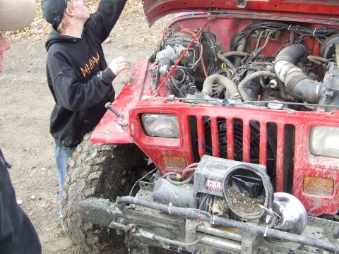 1990 Ford Bronco - Red Jeep Wrangler with hood open, engine exposed, and a winch on the front bumper.