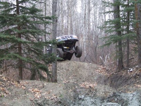 1990 Ford Bronco - Vehicle attempting an obstacle on a dirt trail in a wooded area.