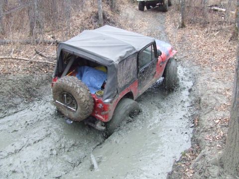 1990 Ford Bronco - Off-roading adventure turns into a mud pit for this Jeep Wrangler on a forest trail.