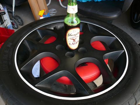 1996 Ford Probe - A bottle of beer rests on a car wheel, which has red inserts visible through its spokes.