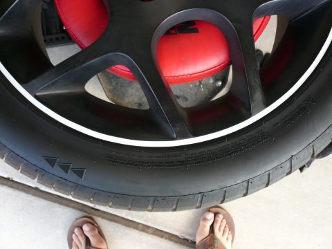 1996 Ford Probe - Close-up of a car wheel and tire assembly, showing the tire's tread and a red brake caliper.