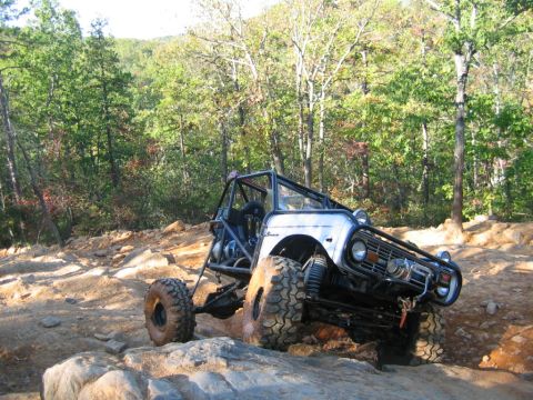 1992 Ford Mustang - Custom off-road buggy navigates a challenging rocky trail in a wooded area.
