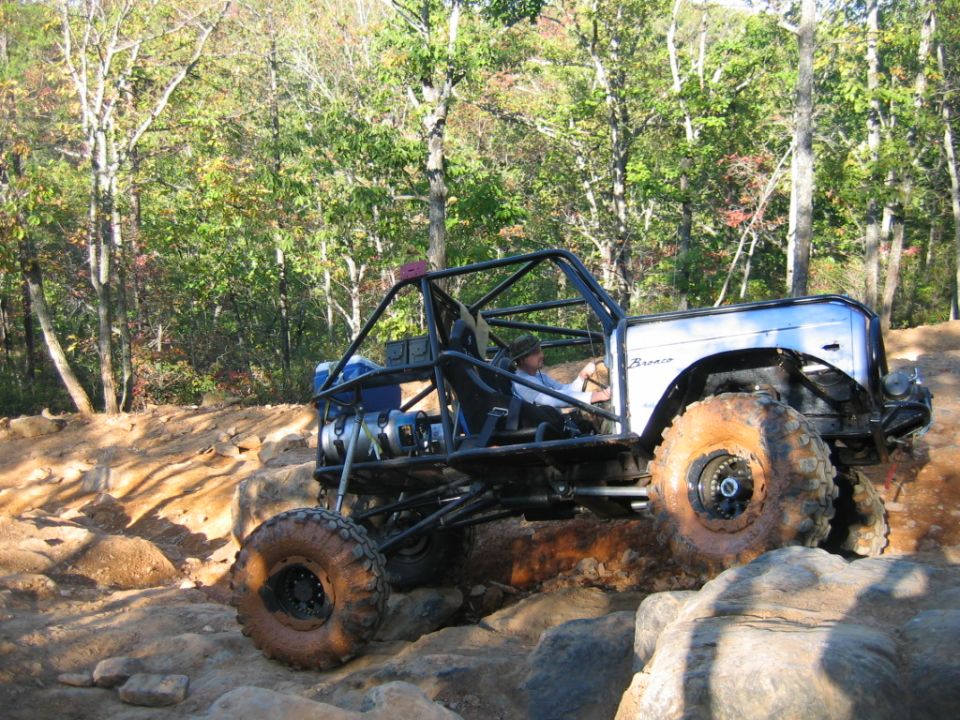 Custom off-road buggy with roll cage navigating large rocks