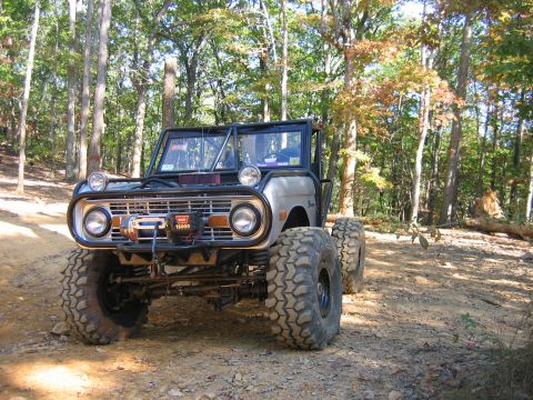 1992 Ford Mustang - A lifted Ford Bronco sits on a dirt path in a wooded area during the fall.
