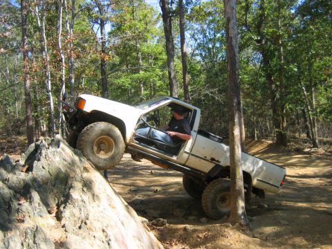 1992 Ford Mustang - Pickup truck navigating a rocky obstacle on an off-road trail.