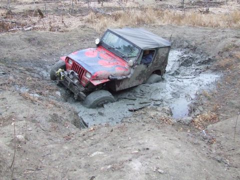 1990 Ford Bronco - This Jeep is really stuck in the mud. The driver is visible inside the vehicle.