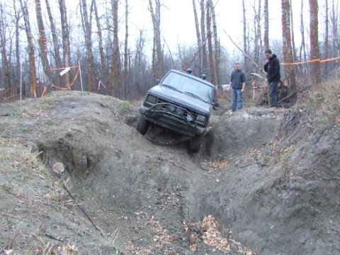 1990 Ford Bronco - A 1990 Ford Bronco tackles a challenging muddy terrain during an off-road event.