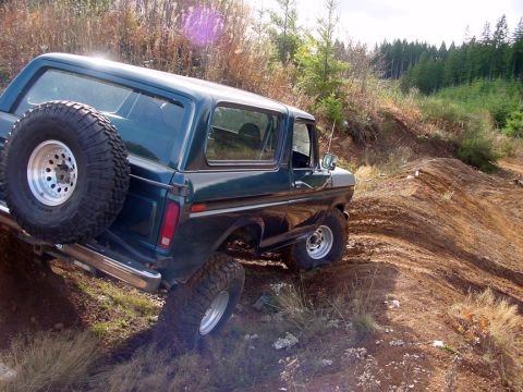 1979 Ford Bronco - This classic Ford Bronco navigates a challenging off-road trail with steep inclines and loose dirt.