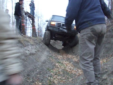 1990 Ford Bronco - A 1990 Ford Bronco navigates a steep, muddy incline during an off-road excursion.