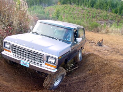 1979 Ford Bronco - This two-tone Ford Bronco navigates a muddy incline on a wooded trail.