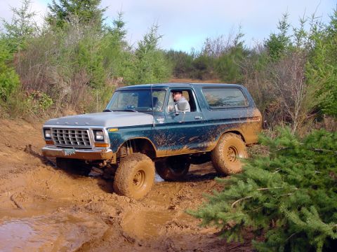 1979 Ford Bronco - A driver navigates a muddy off-road trail in a classic Ford Bronco.