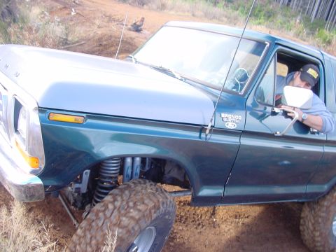 1979 Ford Bronco - A green Ford Bronco with lifted suspension and large tires is driven off-road.